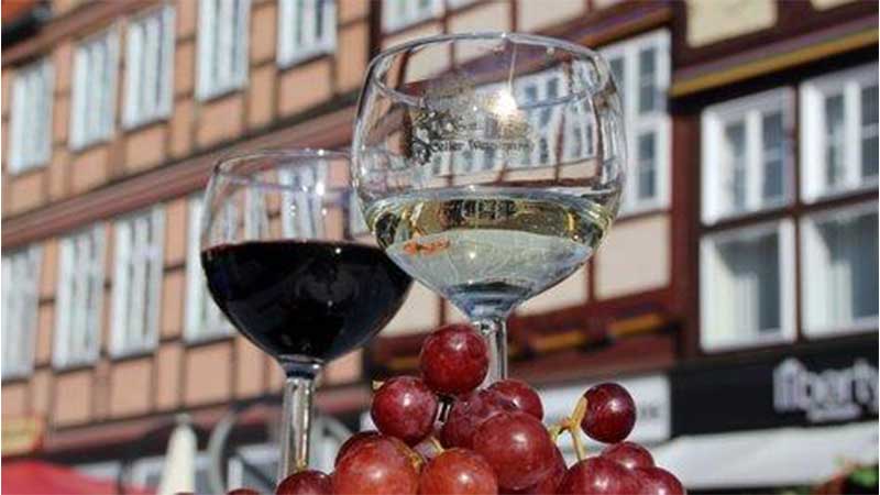 vackra korsvirkeshus i bakgrunden och vinglas i f�rgrunden p� en uteservering under en vinresa till Celle med Tj�rnarpsbuss.