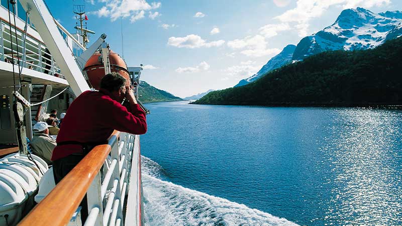 Utsikt frn Hurtigruten  fjordlandskap med spegelblankt vatten, sntckta berg - Res dit med Tjrnarpsbuss